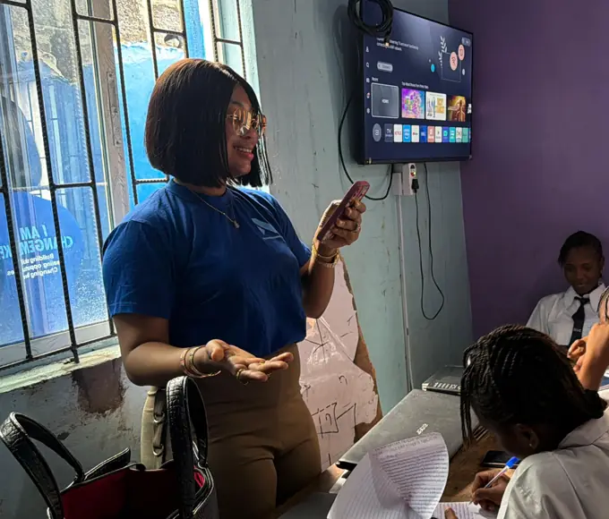 Sandra in a Nezar Foundation shirt talking with students